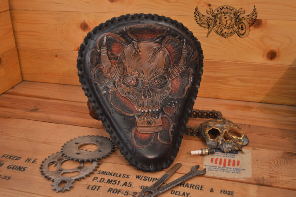 Handmade bobber solo seat with a custom design of a horned skull made out of leather which is hand tooled and laced.