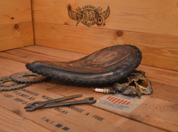 Handmade bobber solo seat with a custom design of a horned skull made out of leather which is hand tooled and laced.