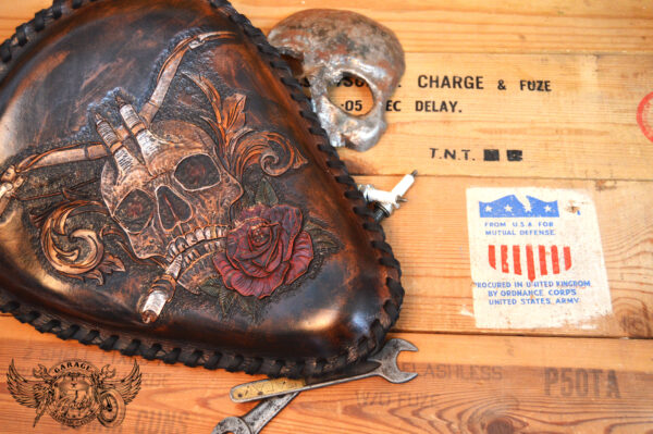 Handmade bobber solo seat with a custom design of a horned skull made out of leather which is hand tooled and laced.