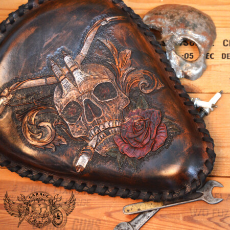 Handmade bobber solo seat with a custom design of a horned skull made out of leather which is hand tooled and laced.