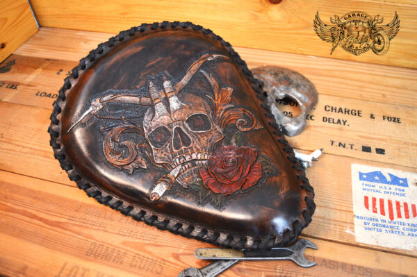 Handmade bobber solo seat with a custom design of a horned skull made out of leather which is hand tooled and laced.